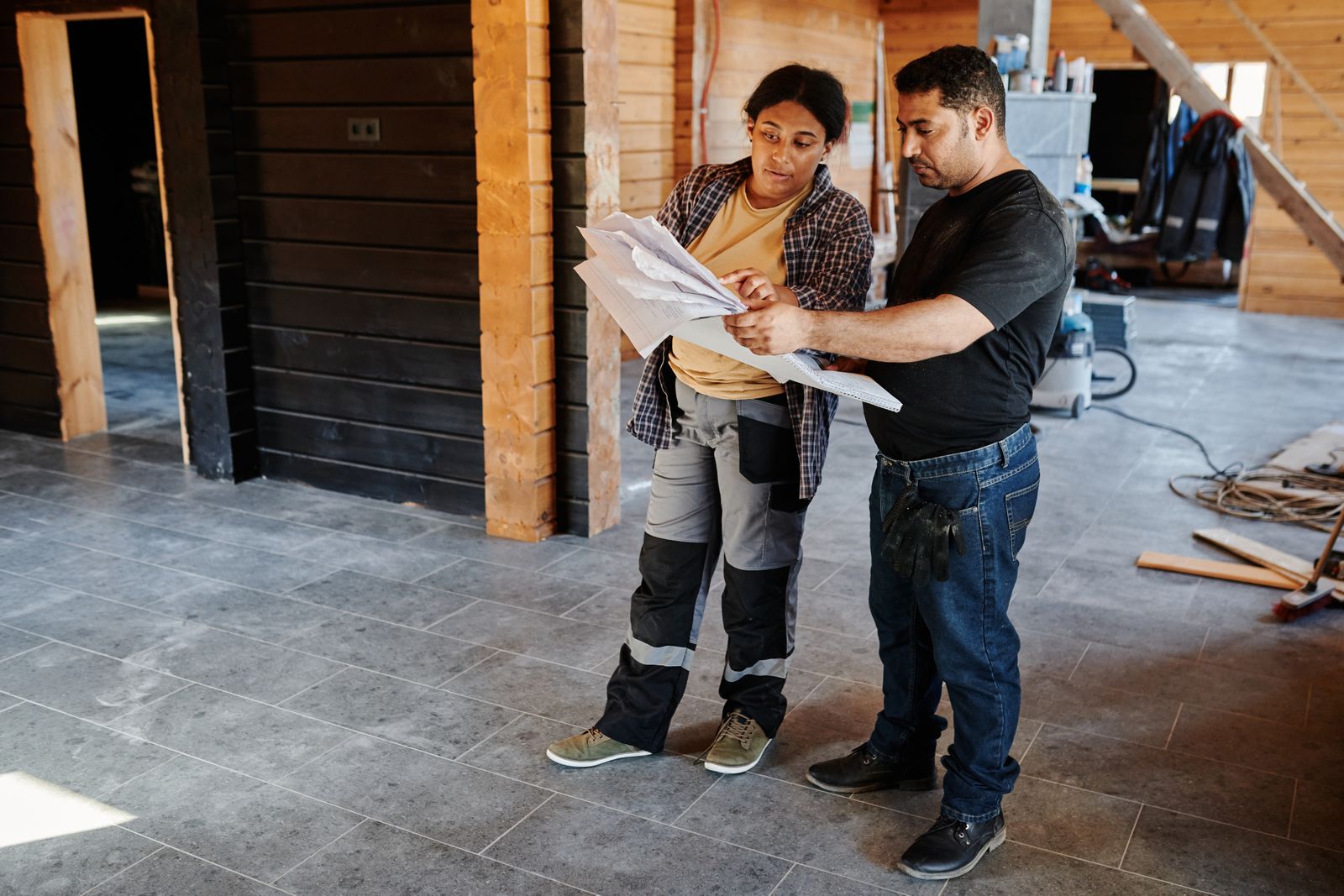 Construction workers examining blueprints inside a building