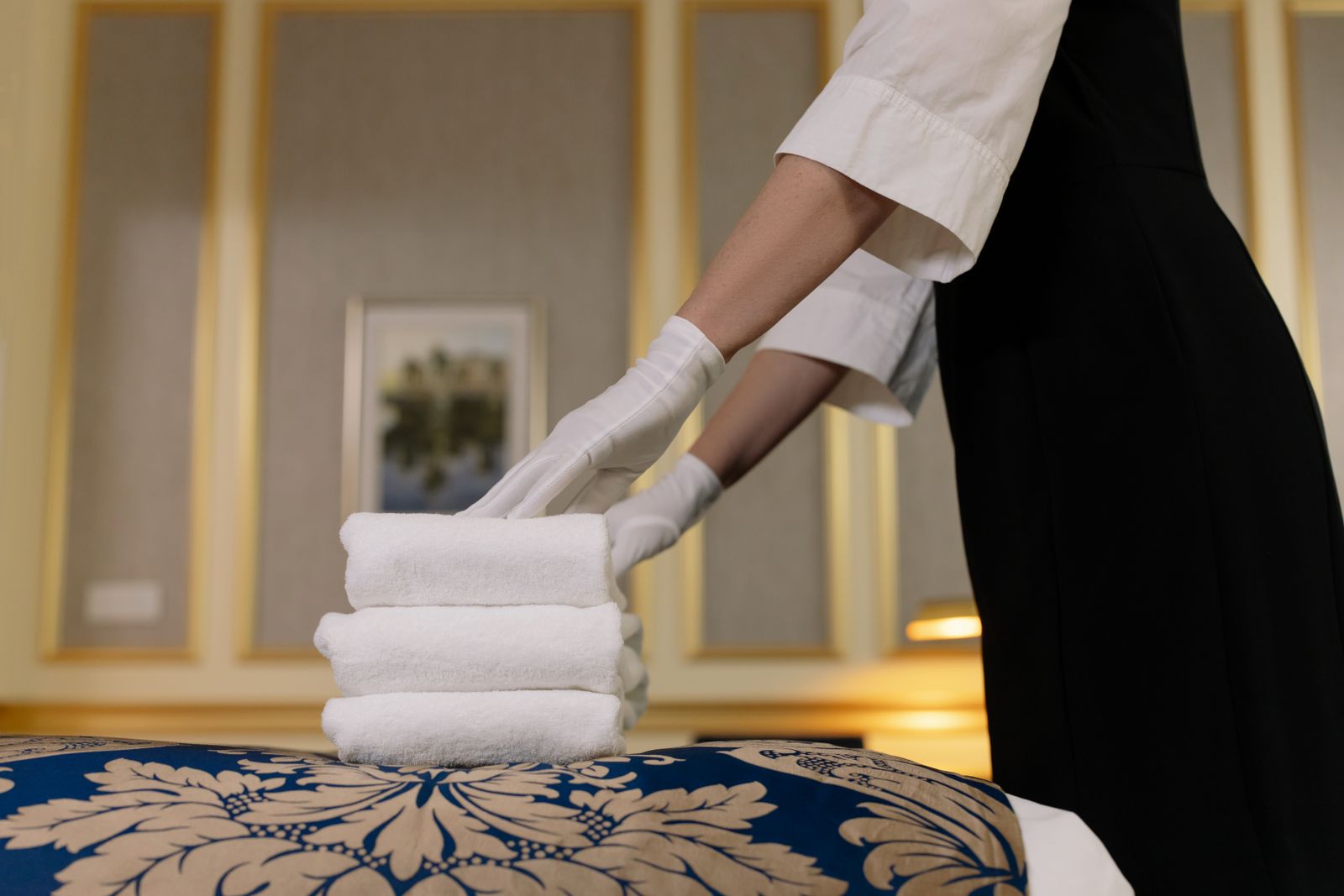 Hotel housekeeper stacking fresh towels in a room