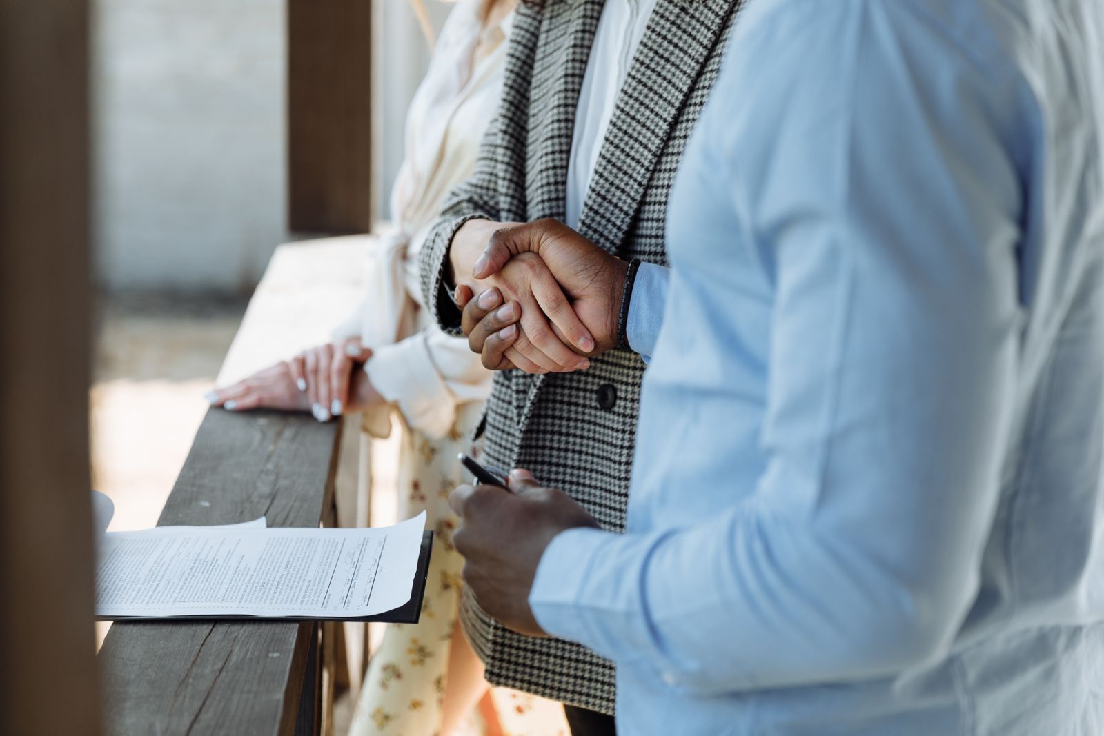 Hands shaking over a signed property agreement