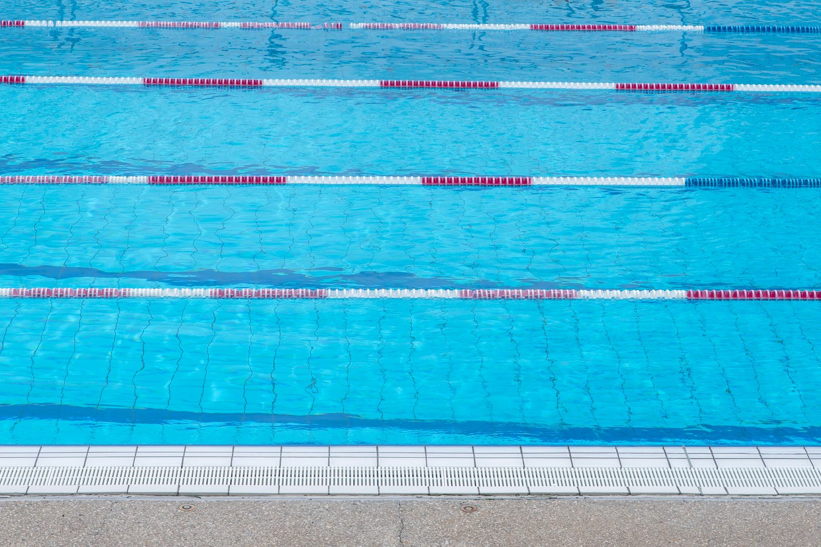 Clear blue outdoor swimming pool with marked swim lanes