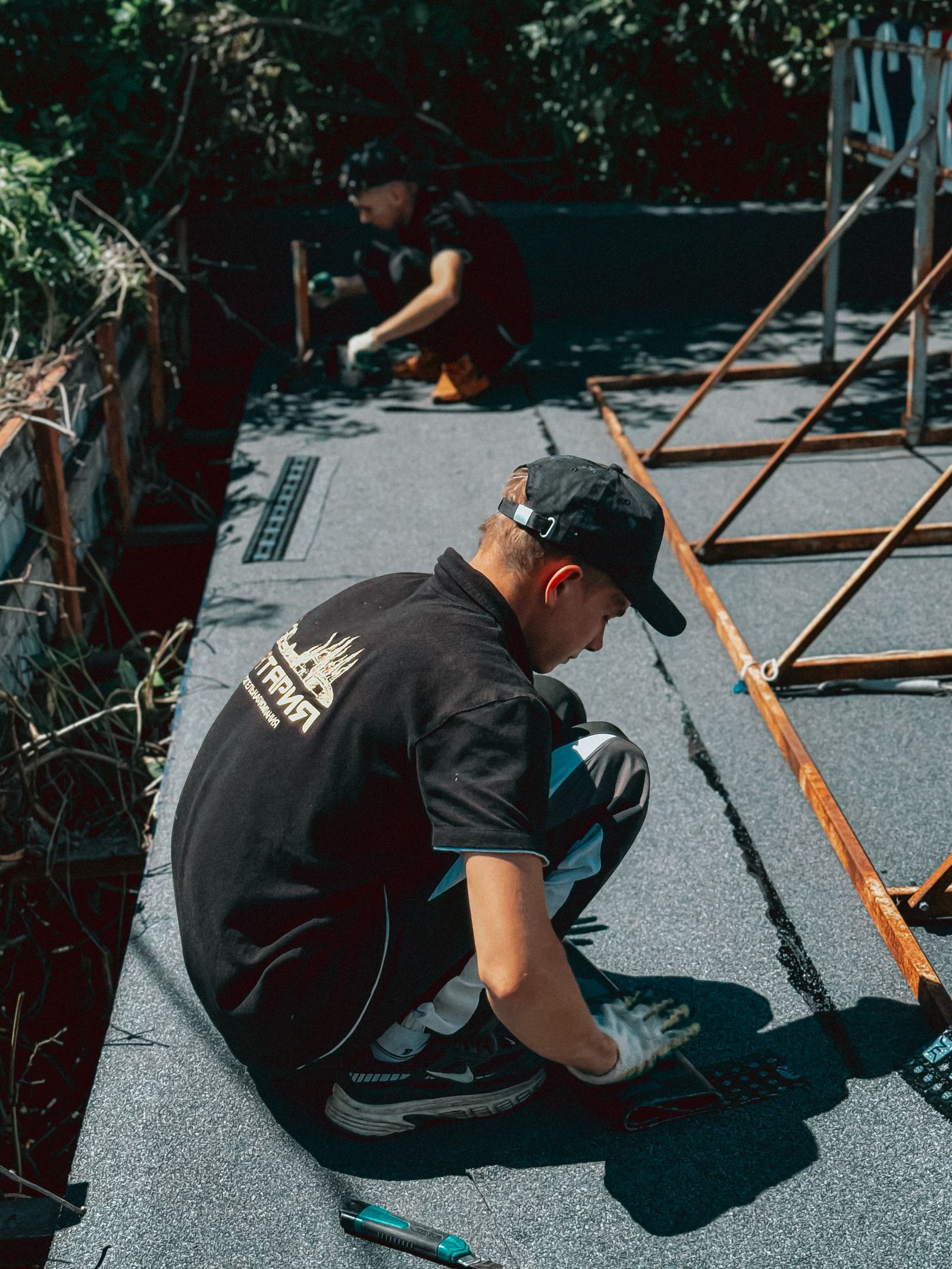 Workers applying waterproofing membrane on a rooftop